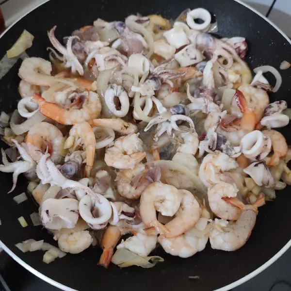 Masukan udang dan cumi-cumi, aduk rata, masak hingga cumi dan udang berubah warna.