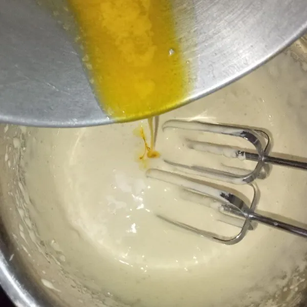 Setelah adonan kental putih berjejak, tuang butter leleh, lalu mixer hingga cukup rata. Matikan mixer