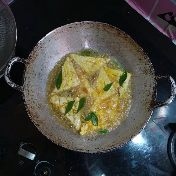 Panaskan minyak dalam wajan, goreng tempe berserta daunnya.