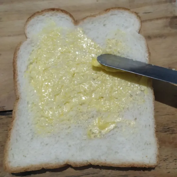 Olesi roti tawar dengan margarin.