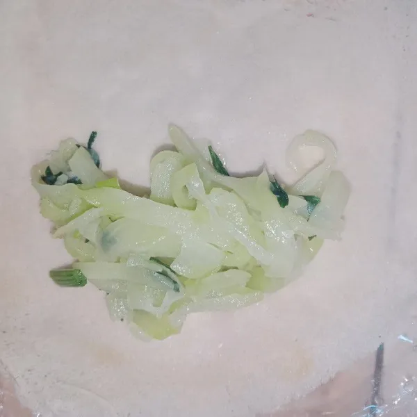 Ambil selembar kulit lumpia lalu isi dengan sesendok isian lalu lipat amplop memanjang.