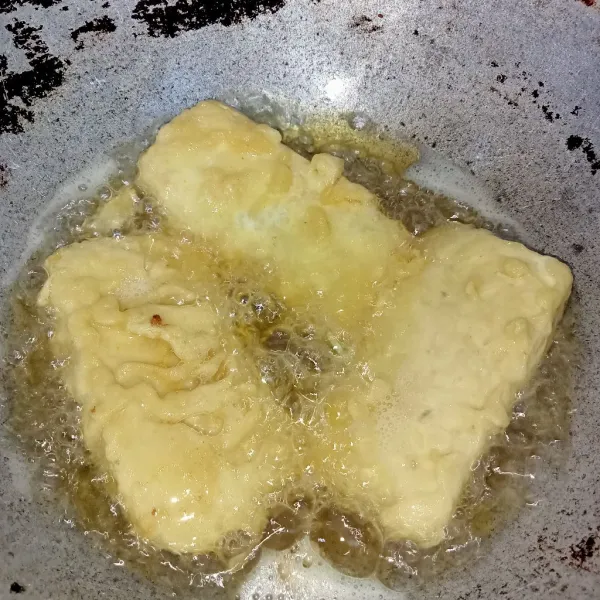 Panaskan minyak goreng secukupnya lalu masukkan tempe dan goreng hingga kuning keemasan. Angkat dan tiriskan.