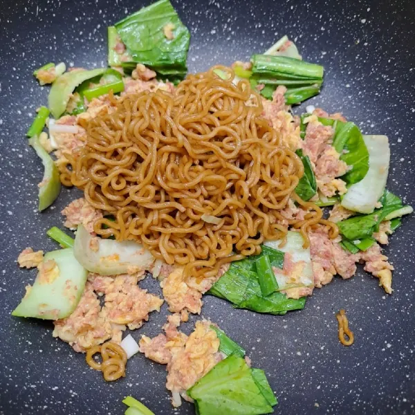 Masukkan mie, aduk sampai tercampur rata. Koreksi rasa sesuai selera. Angkat dan sajikan.