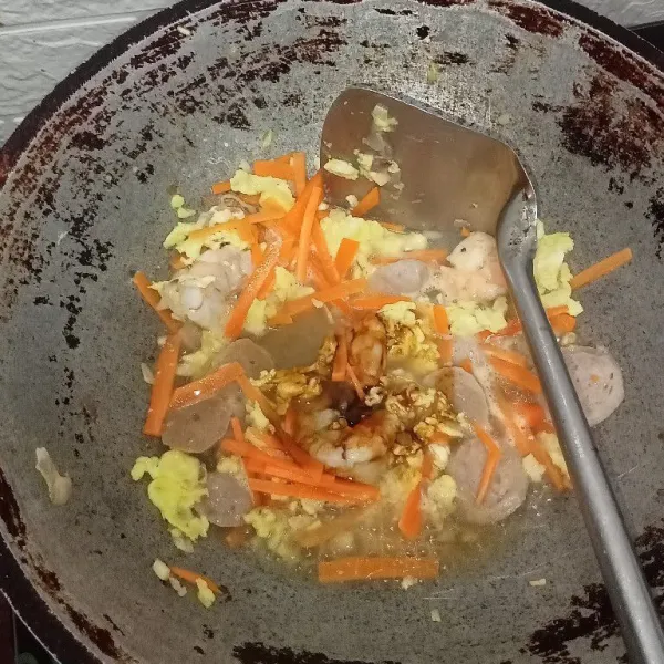 Masukkan wortel lalu tuang air tambahkan kecap asin, saus tiram, kecap manis, lada dan kecap ikan aduk rata masak hingga wortel setengah matang.