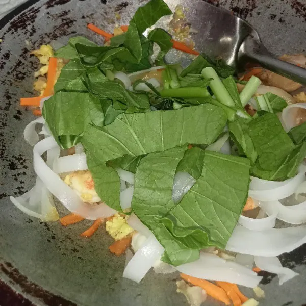 Kemudian masukkan kwetiau dan sawi, aduk rata.
