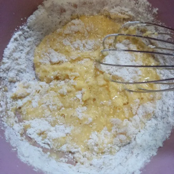 Masukkan tepung terigu, baking powder dan garam sedikit demi sedikit sambil terus di aduk hingga adonan licin dan tidak bergerindil.