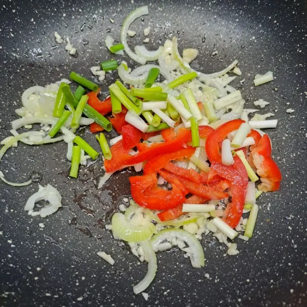 Masukkan paprika merah dan daun bawang. Tumis sebentar asal layu.