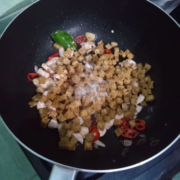 Masukkan tempe, garam, gula, lada, dan kaldu bubuk. Boleh ditambahkan sedikit air agar tidak terlalu kering. Aduk-aduk hingga tercampur rata.