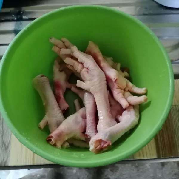 Potong bagian kuku ceker. Bersihkan kulitnya. Kemudian cuci bersih ceker.