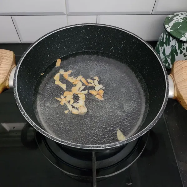 Masukkan bawang putih goreng ke dalam panci yang sudah berisi air mendidih.