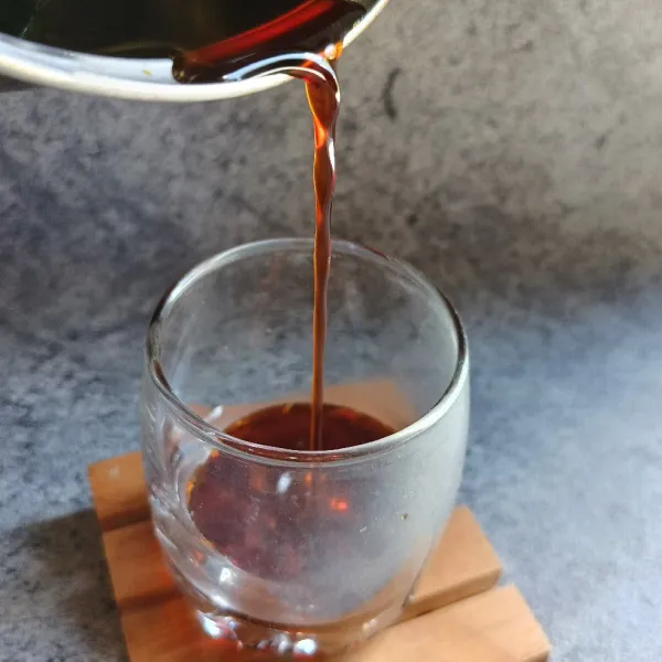 Tuang sirup gula merah kedalam gelas.