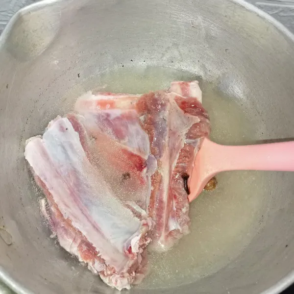Tuang air kemudian masukkan iga kambing, rebus hingga iga empuk (tutup rapat panci supaya daging iga cepat empuk).