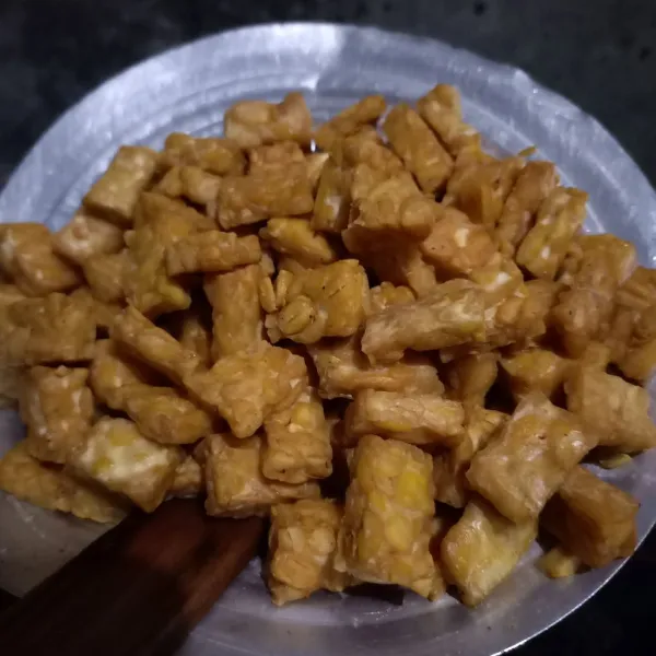 Potong-potong tempe dan goreng sampai kecoklatan.