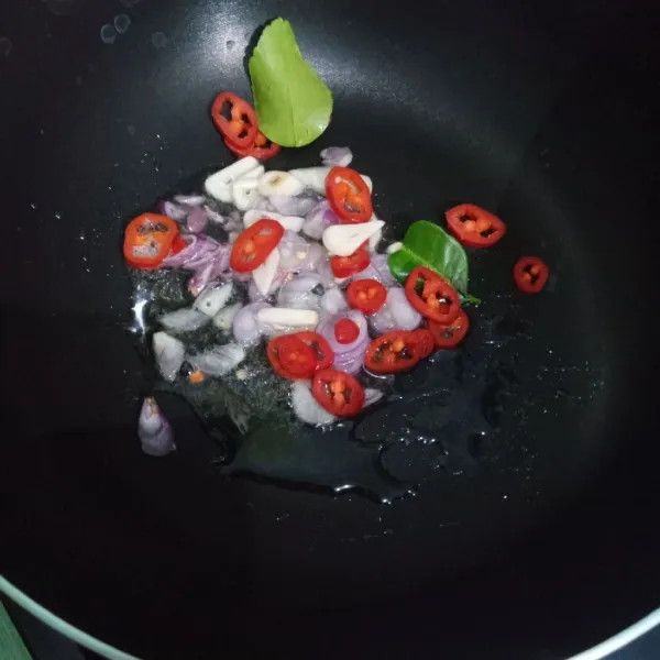 Panaskan minyak, tumis bawang merah, bawang putih, cabai merah, dan daun jeruk sampai harum.