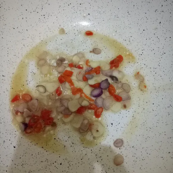 Tumis bumbu iris hingga layu dan harum.