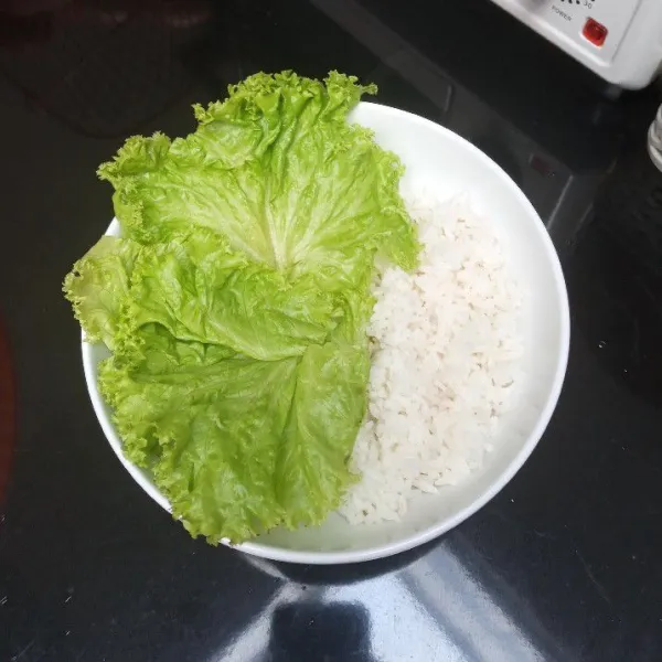 Siapkan nasi di mangkuk, taruh selada di atas salah satu sisinya.