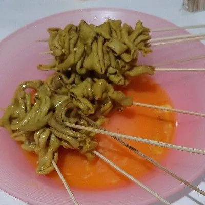 Kemudian tusuk usus dengan tusukan sate lalu balur dengan telur kocok.