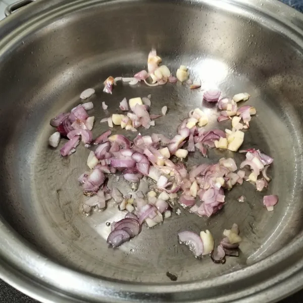 Tumis bawang merah dan bawang putih sampai layu dan harum.