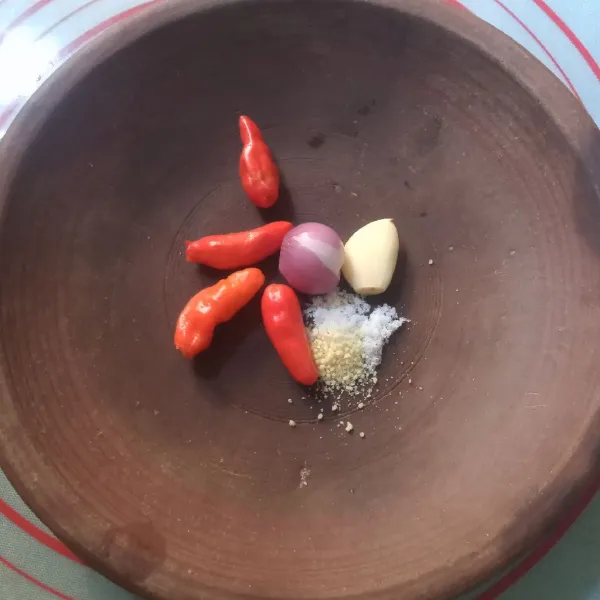 Dalam cobek masukkan cabe, bawang merah, bawang putih, garam dan penyedap, uleg kasar.