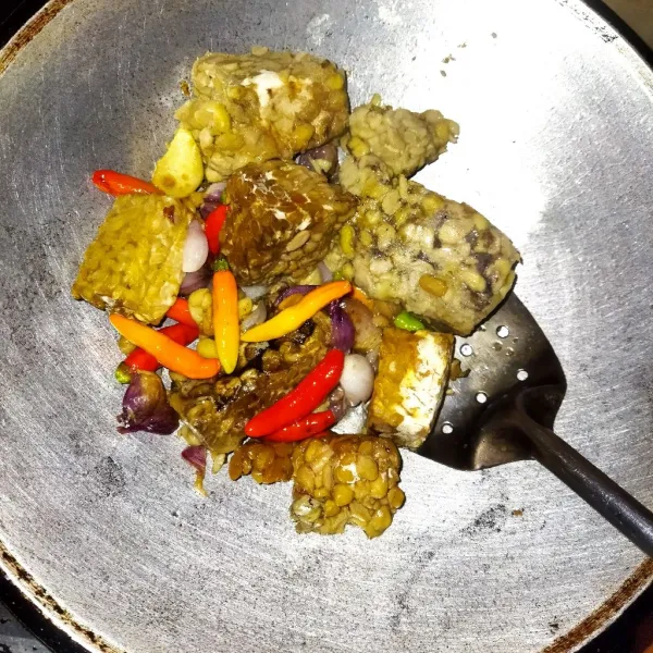 Panaskan minyak, kemudian goreng bawang putih sampai harum. Masukkan bawang merah, cabai, dan tempe. Goreng sampai semua bahan matang.