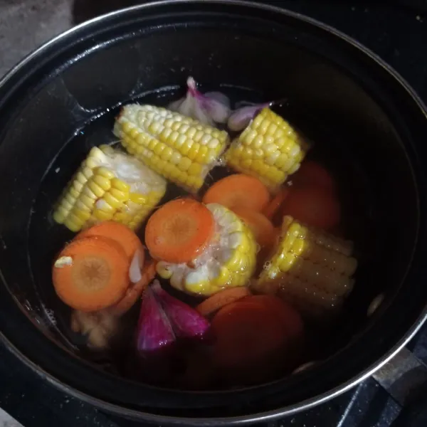 Sisihkan air, masukkan ulegan bawang merah, kencur, jagung manis dan wortel masak sampai setengah matang.