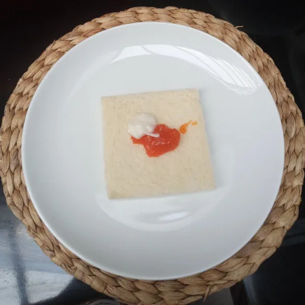 Ambil 1 lembar roti tawar, beri saus dan mayonaise, ratakan.