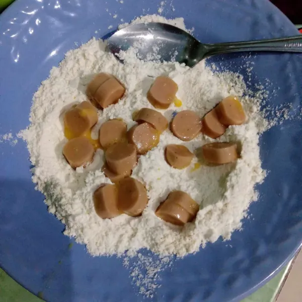 Balut sosis dengan tepung hingga terselimuti.