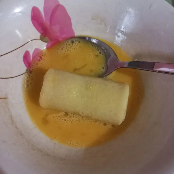 Kocok telur, kemudian gulingkan sosis solo, dan balur hingga merata.