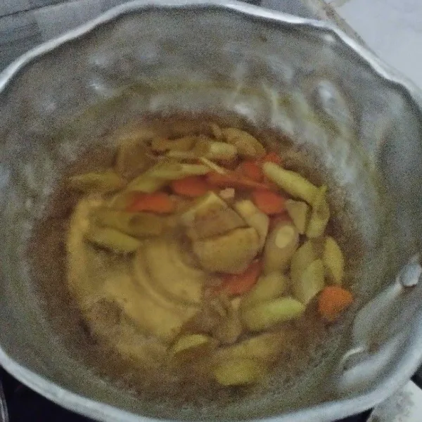 Masukkan irisan jahe, kunyit dan weruh ke dalam panci.
