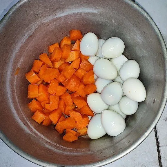 Rebus telur puyuh lalu kupas. Bersihkan wortel dan potong dadu.