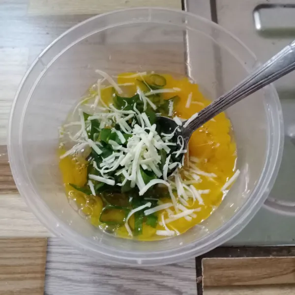 Masukkan keju dan daun bawang, aduk rata kembali.