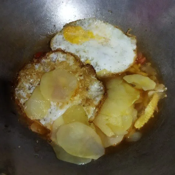 Selanjutnya masukkan gorengan telur dan kentang, masak sebentar.