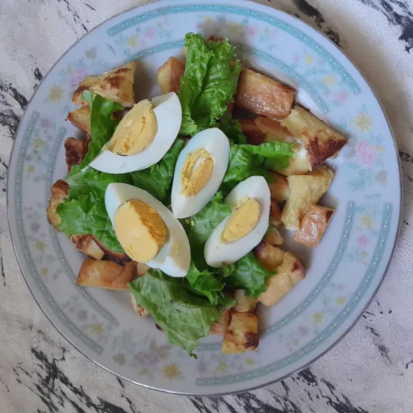 Letakkan daun selada dan potongan telur.