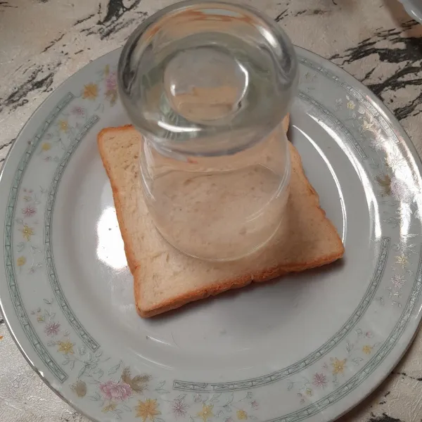 Bolongkan roti menggunakan gelas.