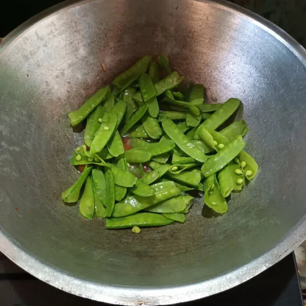 Lalu tumis bawang putih sampai harum. Masukkan cabe, wortel dan air. Rebus sebentar sampai wortel empukk emudian masukkan kacang kapri. Aduk.