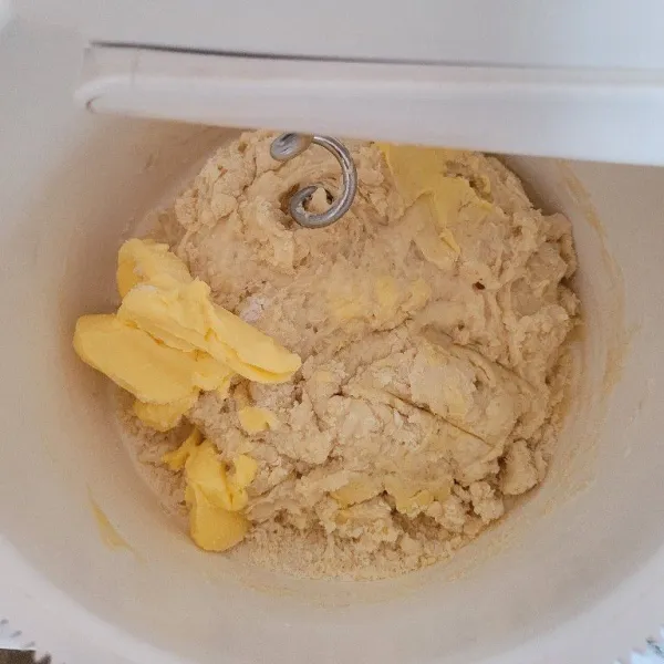 Setelah adonan setengah kalis, masukkan mentega sebanyak 45 gram dengan sedikit garam, kemudian mixer hingga kalis