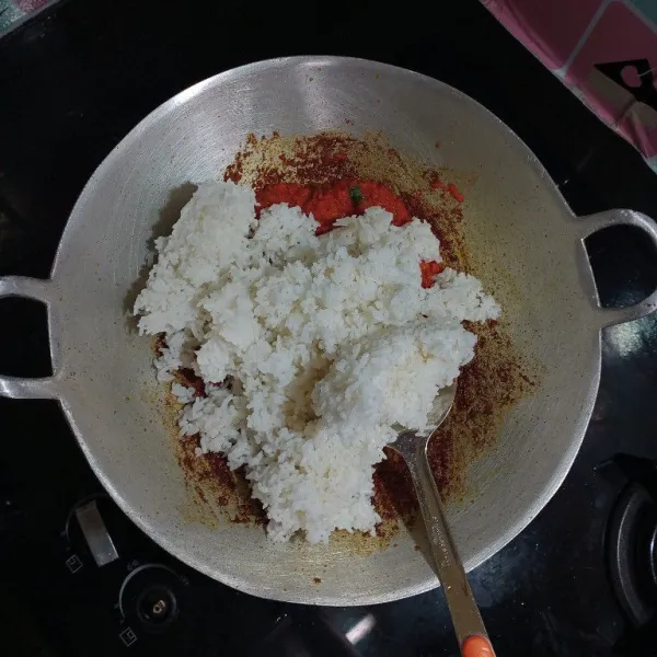 Masukkan daun bawang dan nasi, bumbui dengan penyedap rasa dan garam, aduk sampai rata, cek rasa.