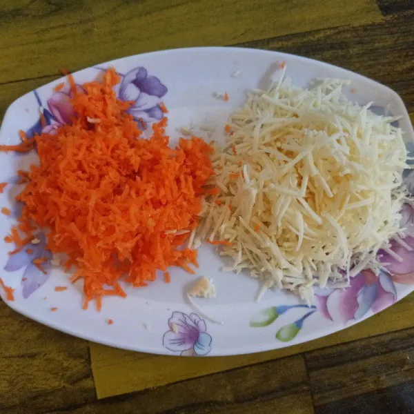 Parut keju dan wortel menggunakan parutan keju.