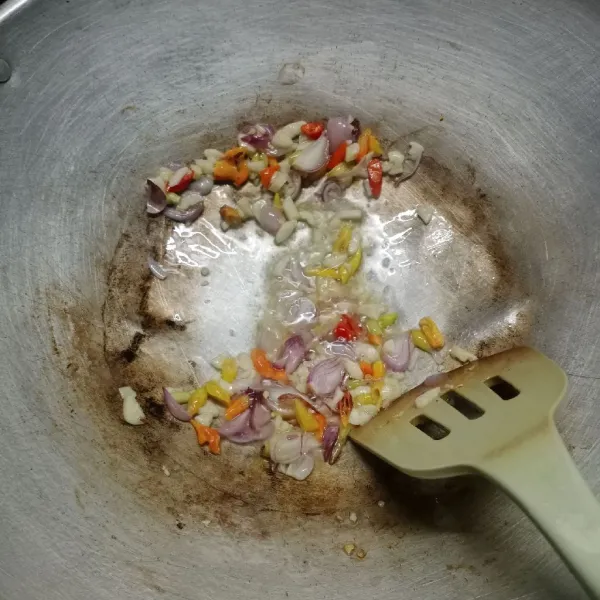 Panaskan sedikit minyak. Tumis bawang merah, bawang putih dan cabe rawit sampai harum.