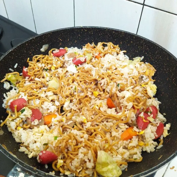 Masukkan mie, tambahkan minyak wijen, kecap ikan, kaldu bubuk dan garam. Lalu masak hingga bumbu tercampur rata.