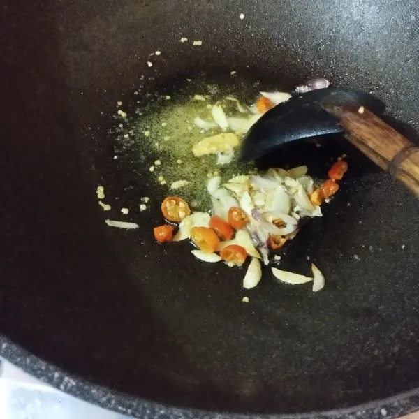 Panaskan minyak lalu masukkan bawang merah dan bawang putih, tambahkan cabe rawit dan aduk rata.