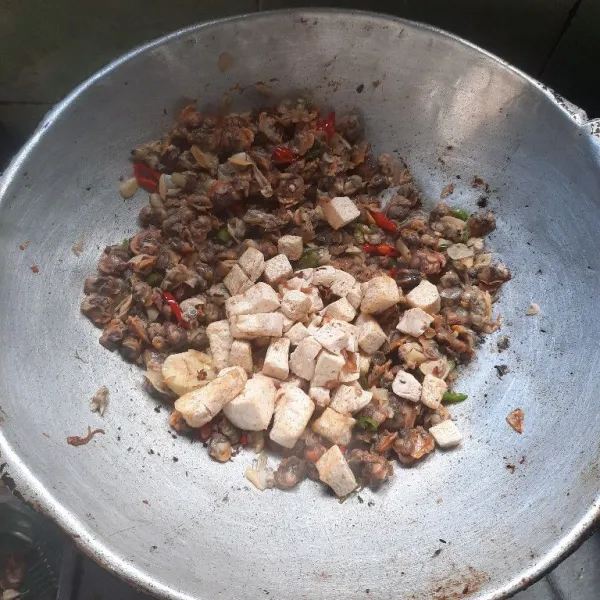 Tambahkan potongan tahu yang sudah digoreng setengah matang.