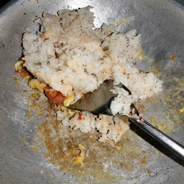 Kemudian tambahkan nasi lalu aduk sampai rata, tambahkan garam dan penyedap rasa.