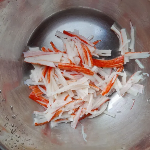 Iris-iris crab stick dan masukkan dalam wadah.