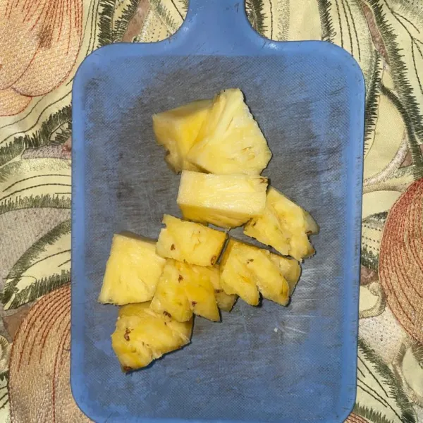 Potong nanas madu yang telah dicuci.