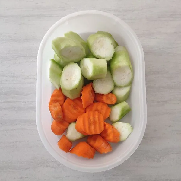 Kupas kulit sayur gambas/oyong dan wortel. Lalu potong sesuai selera. Cuci dengan air, sisihkan.