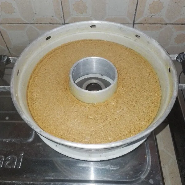 Masukkan adonan ke dalam baking pan ukuran 28 cm yang sudah diolesi margarin dan ditaburi tepung dengan cara disaring. Kemudian panggang dengan api sedang. Panggangan sudah dipanaskan sebelumnya selama 10 menit