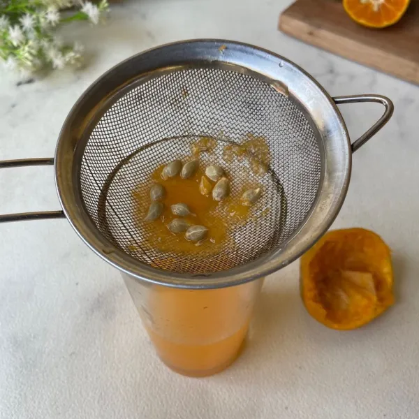 Peras dan saring sari jeruk dan masukkan ke dalam gelas.