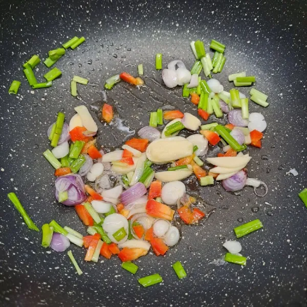Tumis irisan bawang merah, bawang putih, daun bawang dan paprika sampai layu dan harum.
