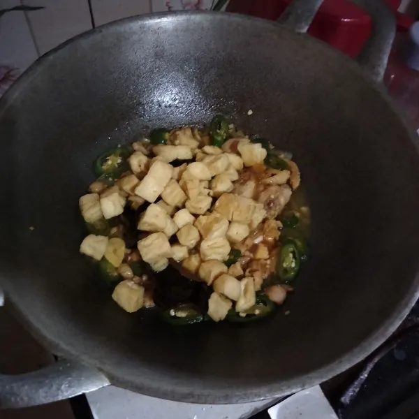 Masukkan tahu yang telah digoreng lalu bumbui garam, kaldu bubuk dan kecap manis. Masak hingga matang lalu koreksi rasa.